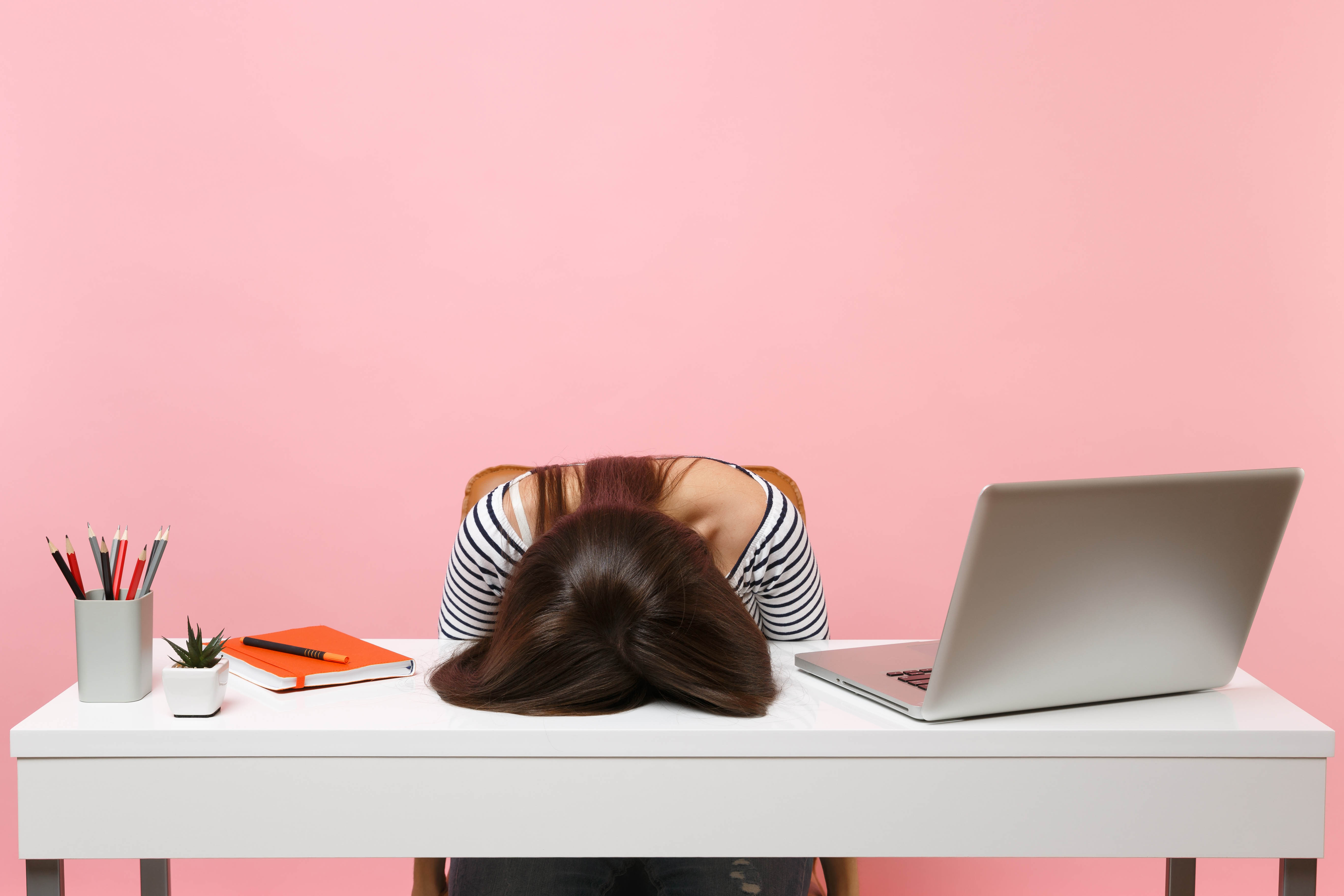 Exhausted girl with her head down on her desk Exhausted girl with her head down on her desk